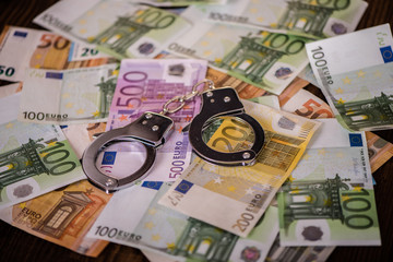 detail close up of handcuffs on money table background 