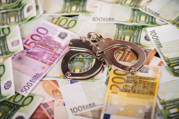 detail close up of handcuffs on money table background 