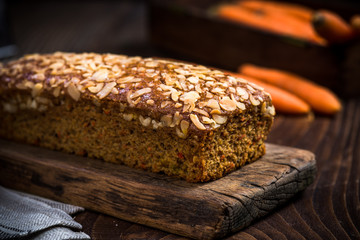 Homemade healthy carrot cake decorated with almonds and walnuts.