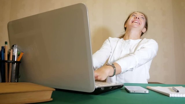 Young woman very quickly typing on a laptop with a facial expression like mad. Heavy work of freelancer.