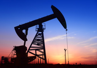 Is operation of pumping unit under the sunset of oilfield, close-up