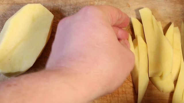 Cutting raw potatoes into parts
