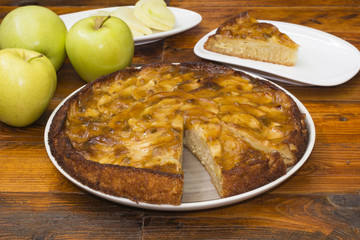 Pastel de manzana con una porción  del pastel y manzanas verdes frescas