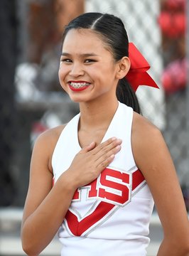 Chinese High School Cheerleader With Hand Over Heart During National Anthem