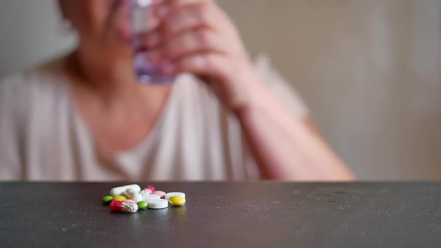 Senior Woman Taking Pills At Home