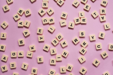 alphabet tiles on pink background. education concept
