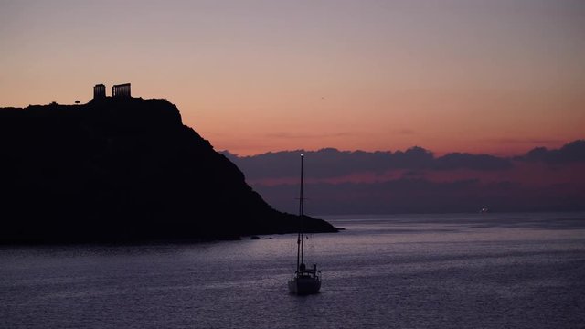 Seascape of the Aegean sea, yacht on water surface. Great early morning view of the Temple of Poseidon, Cape Sounio, Greece Europe.