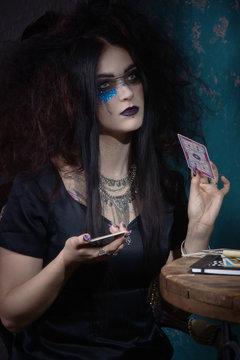 Evil witch conjures with tarot cards
