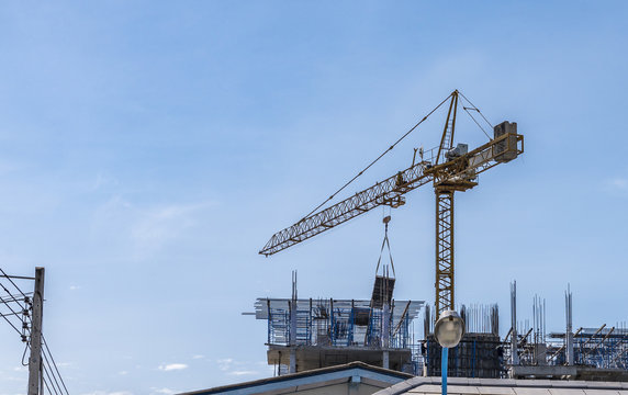 Construction site with cranes on blue sky background. Crane is working.