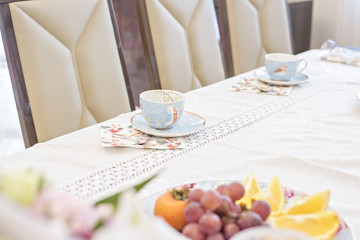 A festive table with cups of flowers and fruits. Delicious cake and cookies