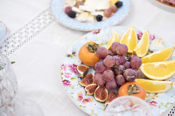 A festive table with cups of flowers and fruits. Delicious cake and cookies