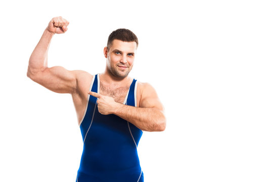 Young dark-haired man wrestling Greco-Rican wrestling, master of sports in grappling in blue wrestling tights smiling and  demonstrate his bicep white isolated background