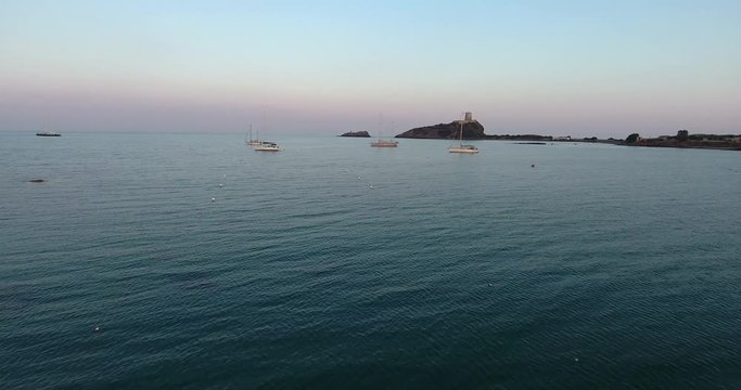 SARDINIA, ITALY  &ndash; JULY 2016 : Aerial shot of Capo Di Pula during beautiful sunset with sea and boats in view