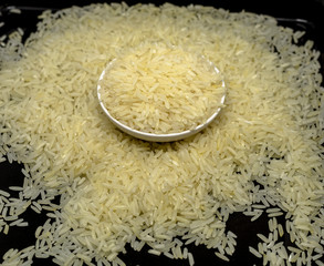 Raw Jasmine Rice seed in bowl isolated in black background, signature of Thailand