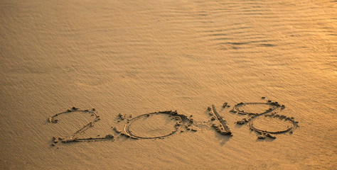 The letters on the sandy beach, the numeric 2018 to welcome the new year