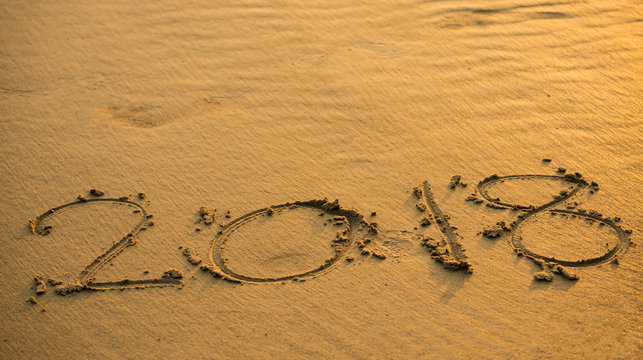 The letters on the sandy beach, the numeric 2018 to welcome the new year