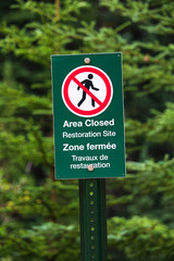A green sign indicating area closed as a restoration site