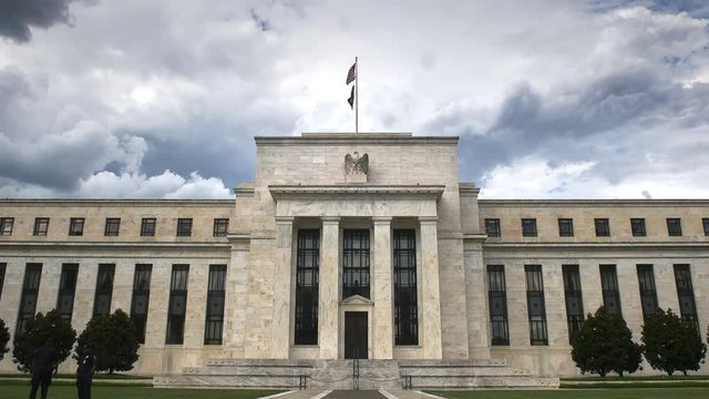 storm clouds behind the exterior of the federal reserve building in washington, dc