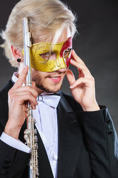 man in carnival mask playing flute