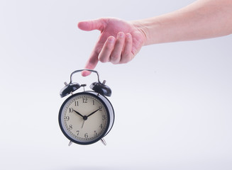 alarm clock or alarm clock with hand on the background.