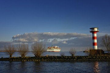 Obraz premium Elbe, Leuchtturm, Containerschiff