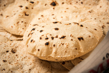 Roti or chapati making machine, selective focus. Indian ready to eat Indian flat bread coming out of machine
