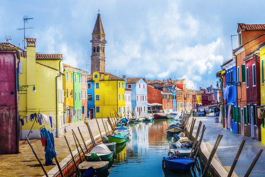 Colorful houses, canal, boat and church on the famous island Burano island, Venice, Italy