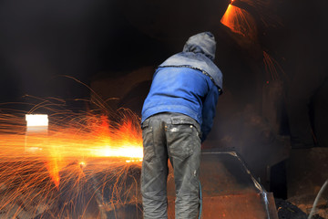 The workshop welder cuts metal值）