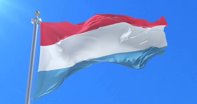 Flag of Luxembourg waving at wind with blue sky in slow, loop