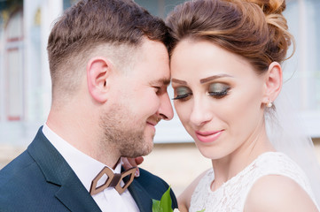 Portrait of a lovely couple of newlyweds is embraced against the backdrop of a vintage building of the exhibition gallery.