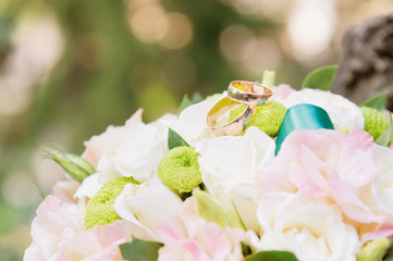 wedding gold rings lie on a wedding bouquet