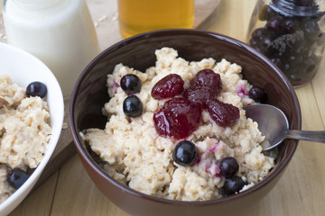 Delicious oatmeal porridge with berry and almonds for breakfast.
