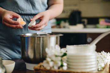 cooking woman breake egg above the bowl