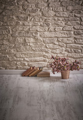 Naklejka premium stone wall books and flowers detail