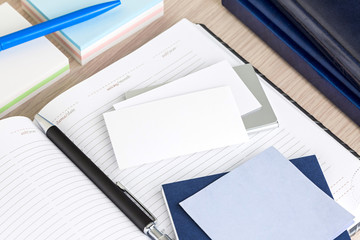 Open blank notepad and pen with blank bussinesscard on a desk of a bussinessman