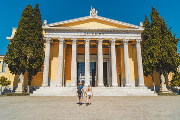 Obraz premium Two people walking to building Zappeion Megaron in the National Gardens of Athens, Greece.