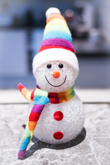 Un petit bonhomme de neige avec son écharpe multicolor.