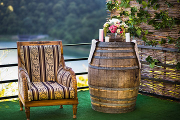 Bouquet and candles on the barrel, next to the chair