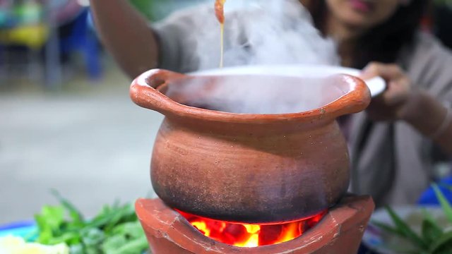 Girl fill Pork and Meat in Clay Pot to make Thai Hot Pot Street Food (Jim Jum), Thai Food