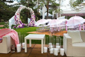 Outdoor wedding ceremony with umbrellas in the forest