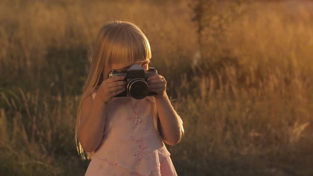 Little girl with camera on nature