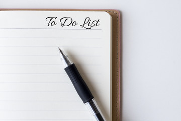 Conceptual,notebook on a white table. open diary and pen with to do list words