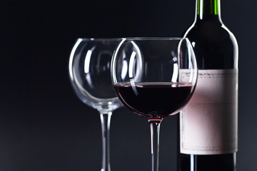 Bottle and glass of red wine .