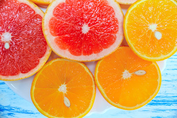 fresh citrus fruits on a light wooden background 