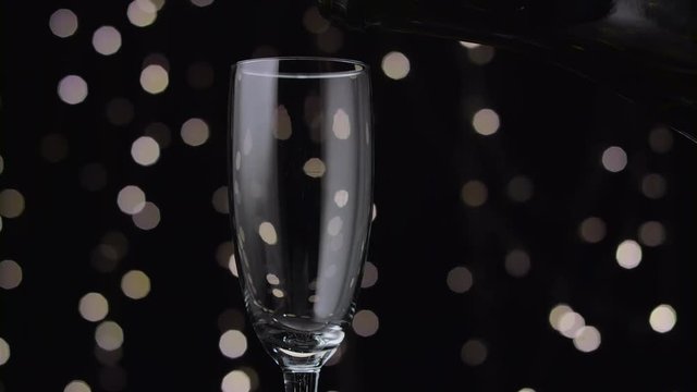 Champagne poured into glass. Bokeh background