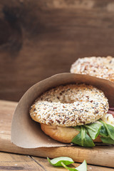 Bagels with salami and onion on a wooden board with free text space. Selective focus.