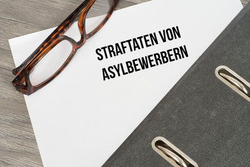 Ein Ordner und ein Dokument über die Straftaten von Asylbewerbern