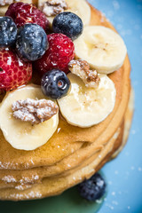 Berries and banana on pancakes.