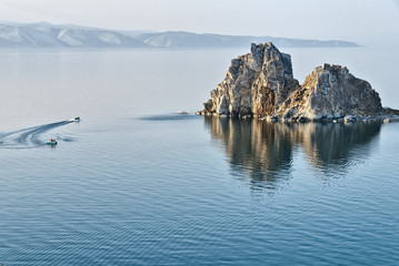 Fototapeta na wymiar boats with people are going around the shaman rock on lake Baika