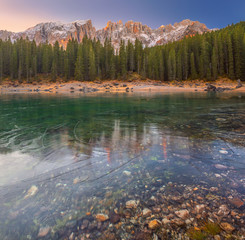 Carezza lake covered with thin layer of ice in autun. Lago di Carezza, Karersee, Dolomites Alps. South Tyrol. Italy.